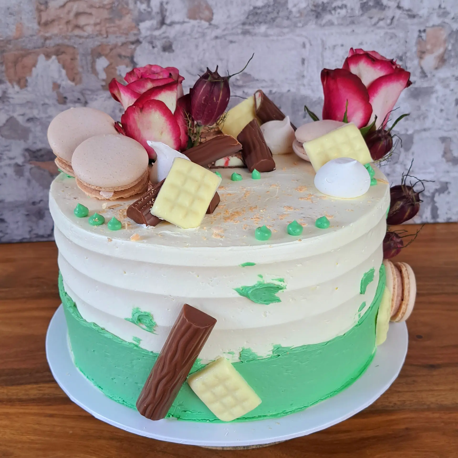 Torte mit Blumen und Macarons